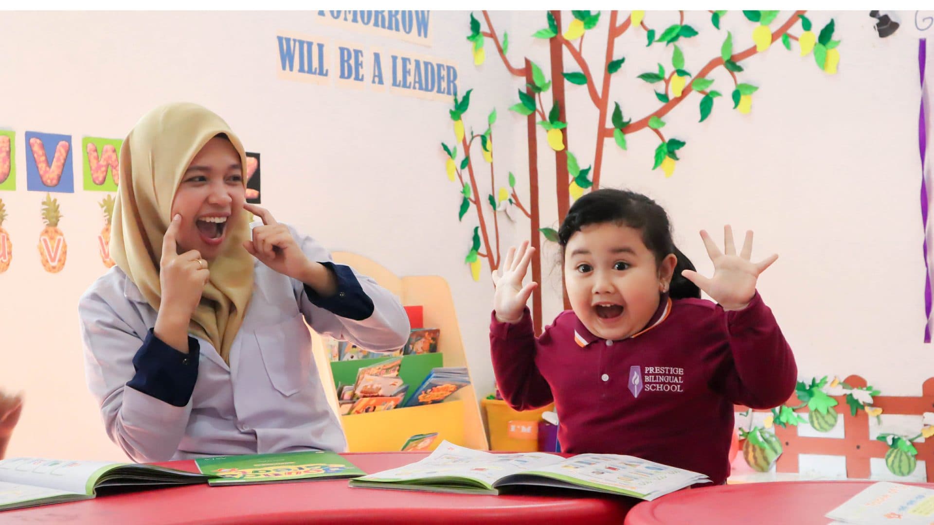 Guru dan siswa membaca buku bersama di ruang kelas
